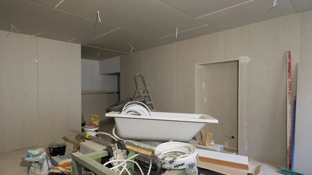 Pièce en chantier de rénovation intérieure avec cloisons en plaques de plâtre, baignoire à poser et escabeau